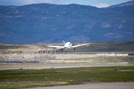 Passenger plane taking off from runway at the airport with mountains in the backgroundの写真素材
