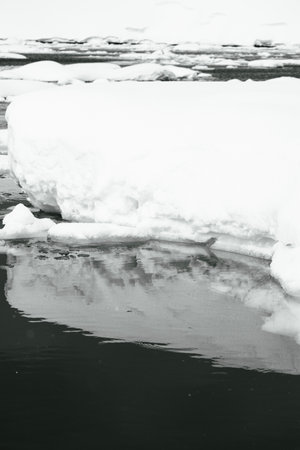 Black and white image with a mirror reflection of an Iceberg in the still water around Enterprise...