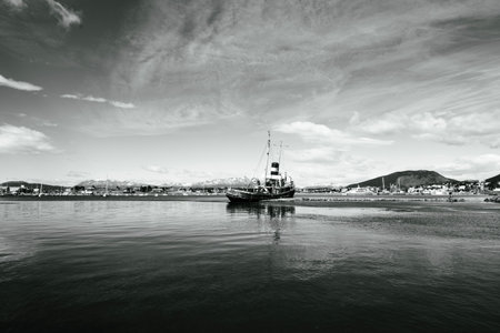 St. Christopher (formerly HMS Justice)  shipwreck with the Ushuaia harbor and Andres Mountains in the background. WWII ear ship now stands as a monument to all ships lost in the reの写真素材