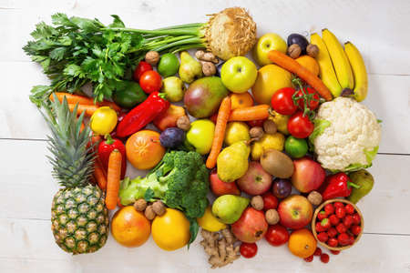White wooden table full of fresh assorted fruit and vegetable. Colorful heap of raw nutritious food on light background. Concept of vitamin and health in flatlay composition.の写真素材