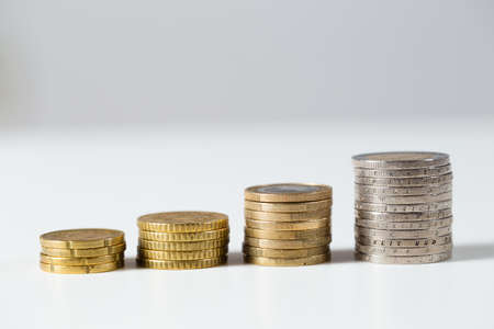 Pile of euro coins prospering on white background. Golden money cash growing in steps. Concept of...