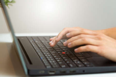 Person working on computer in office space from close up