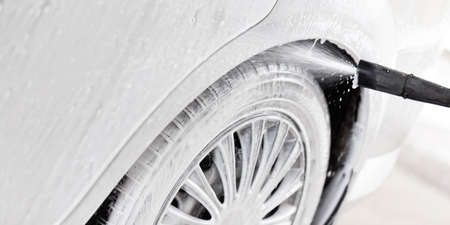 Washing car with high pressure cleaner with soap and water in washbasinの写真素材