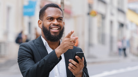 Close up ethnic African American bearded man tourist businessman with smartphone using navigation...