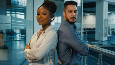Business portrait diverse coworkers two colleagues African American confident woman businesswoman and Arabian Indian man ethnic businessman in office posing for camera with crossed arms crossing handsの写真素材