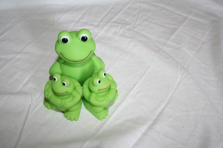Three plastic frogs on a white background.の写真素材