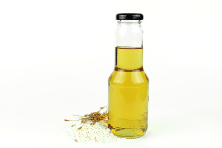 Rice bran oil in bottle glass and riceの写真素材