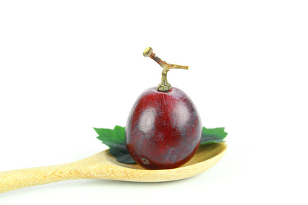 Ripe red grape with leaves isolated on whiteの写真素材