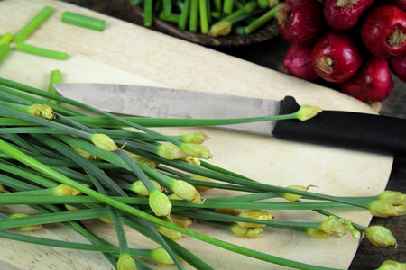 bunch of fresh chives on a wooden cutting board