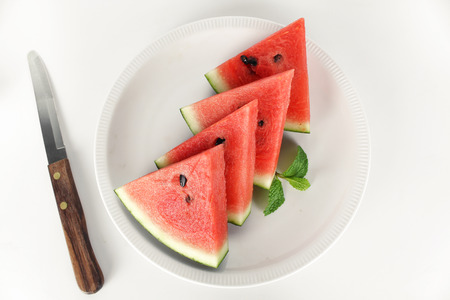 red watermelon whole and slice on plate with mint leafの写真素材