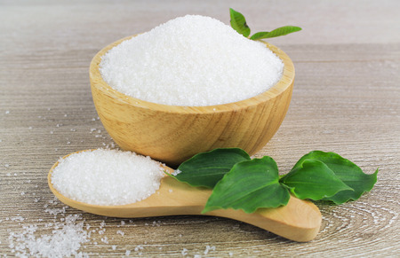 Sugar in wooden bowl isolated on whiteの写真素材