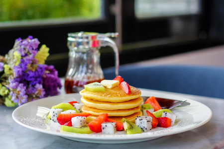 Pancakes for breakfast topped with strawberry and kiwiの写真素材