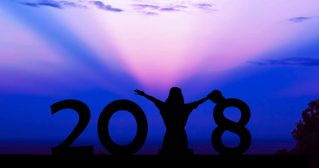 Silhouette young woman sitting on the ground, for 2018 new yearの写真素材