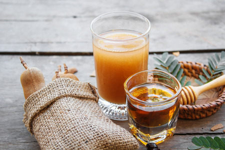 Tamarind and tamarind juice with honey on wooden backgroundの写真素材