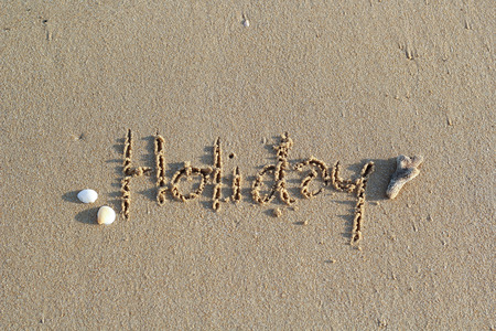 Hello Holidays. written in sand at the beachの写真素材