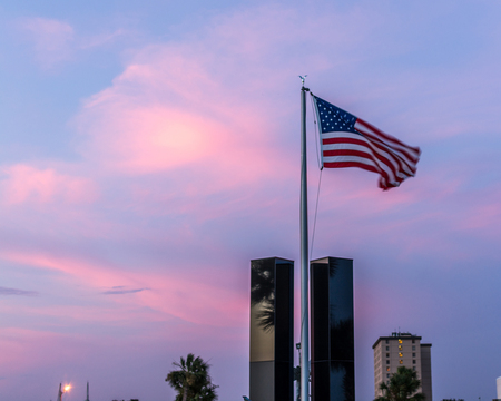 American flag flying over the 9-11 Memorial at sunset at Panama City Marina in Panama City, Florida on 7/11/15.のeditorial素材