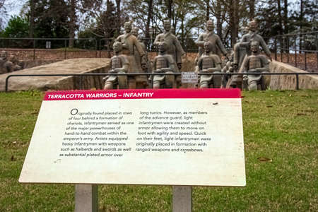 Troy, Alabama, USA-March 20, 2021: Informational sign in the foreground with terracotta warriors out of focus in the background at the Janice Hawkins Cultural Arts Park on the campus of Troy University.のeditorial素材