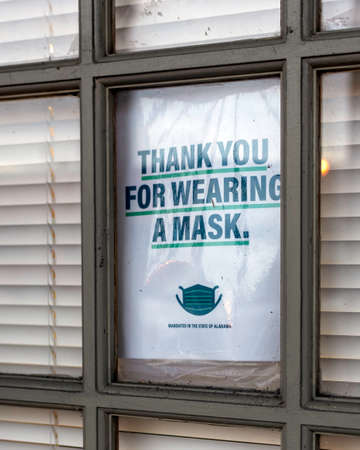 Close up of a sign in a door window thanking patrons for wearing a mask inside.