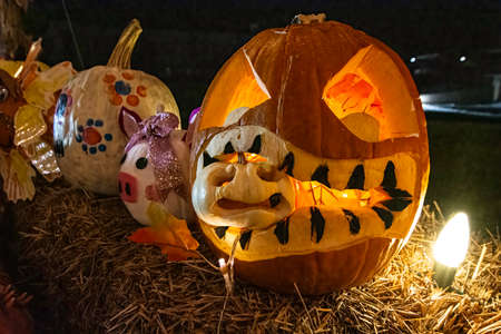Prattville, Alabama, USA - Oct. 26, 2021: A pumpkin carved to appear to be eating a smaller pumpkin at the Parade of Pumpkins in downtown Prattville.のeditorial素材