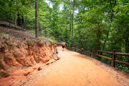 Lumpkin, Georgia, USA- June 6, 2021: A male hiker descends into the canyon via the hiking trail at Providence Canyon State Park in southwest Georgia.のeditorial素材