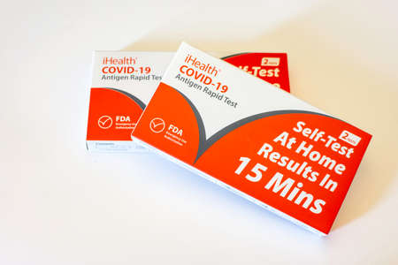 Two boxes of iHealth self-test kits for Covid-19 provided for free by the government on a white background.のeditorial素材
