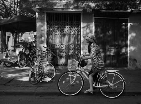 Hoi Ann, Vietnam - January 29, 2017 - Street girl on bicycle ready to cycle around in ancient town of Hoi An.のeditorial素材