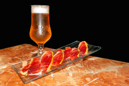 typical spanish tapas of beer and ham