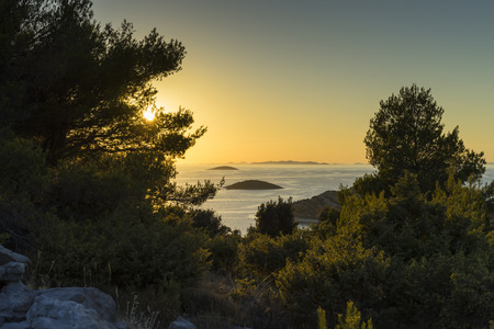 Beautiful nature and landscape photo of Croatia and Adriatic Sea. Nice, warm summer evening with clear yellow sky and lovely ocean. Calm, joyful and happy image.の写真素材