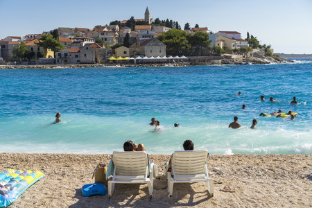 Primosten, Croatia, August 14 2017, People swimming in water at beautiful beach, Nice warm summer day with blue sky and lovely ocean.のeditorial素材
