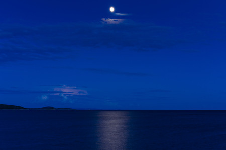Adriatic Sea at dusk in Razanj Croatia. Beautiful nature and landscape photo of blue colorful evening at ocean. Moon in sky and reflection in water. Calm, peaceful image. Nice, joyful outdoors pictureの写真素材