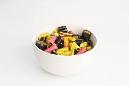 Details of colorful tasty  sweet finish licorice candy on white background in bowl. Nice closeup photo of sweets and goodies. Beautiful background photo of food confetti. Good textures of snacksの写真素材