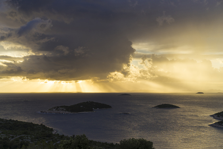 Beautiful nature and landscape photo of stormy sky at sunset evening in Croatia. Nice color in Adriatic Sea and the clouds. Scenic outdoors image at Dalmatia coast line. Islands, sunrays and horizon.の写真素材
