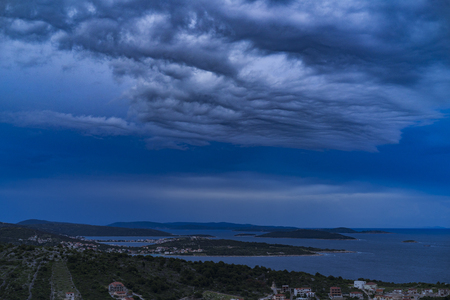 Beautiful nature and landscape photo of stormy sky at dusk evening in Croatia. Nice blue color in Adriatic Sea and the clouds. Scenic outdoors image at Dalmatia coast line. Islands and horizon.の写真素材