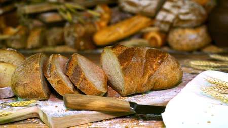 Freshly Baked Bread With Ears of Wheat and a Knife on a Rustic Table.