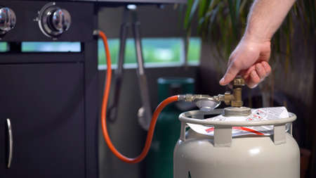 Male Hand Opens the LPG Cylinder Valve for Barbecue