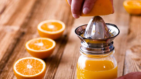 Making Fresh Orange Juice with a Handheld Orange Juicer.の写真素材