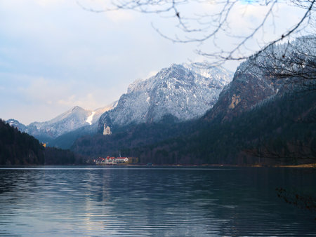 Mountain landscape at a serene lake during winter, showcasing snow-covered peaks and calm watersの写真素材