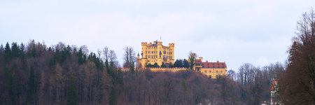 Historic castle perched on a hillside amidst a serene landscape in early morning lightの写真素材