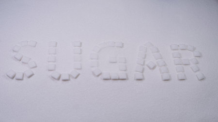 Sugar cubes arranged to spell sugar on a white surface creating a simple but striking visual statement about sweetnessの写真素材