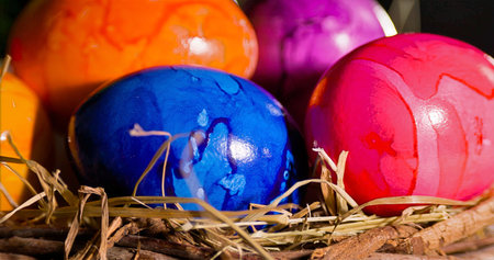 Artisan Craft Scene Showing Vividly Colored Eggs Within Textured Straw Nest Under Warm Spring Light