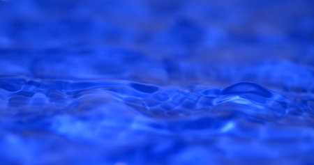 Water ripples reflect light during the daytime in a clear blue pool