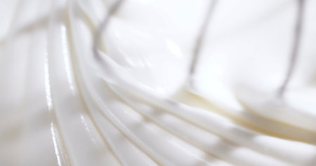 Whisk is moving in a bowl while making batter in a home kitchen during the early morning on a...