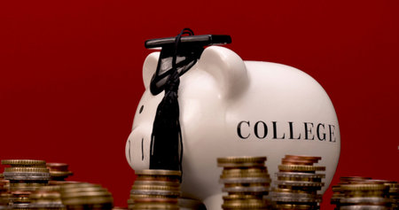 Piggy bank with college label surrounded by coins representing savings for higher education and...