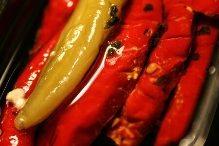 red and green chillies with cheese filling and herbs in olive oilの写真素材