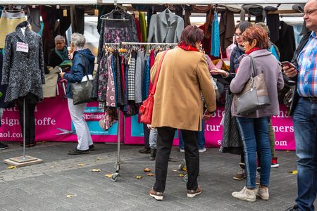 Neuwied, Rhineland Palatinate, Germany - November 2, 2019: interested customers in front of  outdoor market stands for textilesのeditorial素材