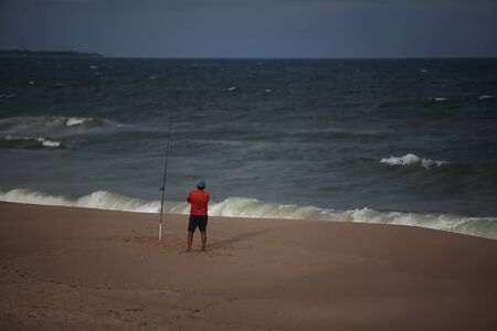 SALVADOR, BAHIA / BRAZIL - October 4, 2017: Fisherman is seen on empty beach in the Jardim de Alah region in Salvador (BA). Cloudy skies may justify the absence of sunbathers (Joa Souza).のeditorial素材