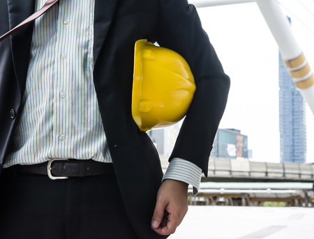 Business man with yellow safety helmet ready to work in the cityの写真素材