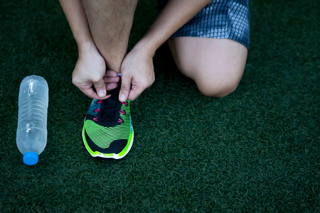 Sport man who has more experience by look at scar at leg and scratch at his shoe prepare himself before his sport activities.の写真素材