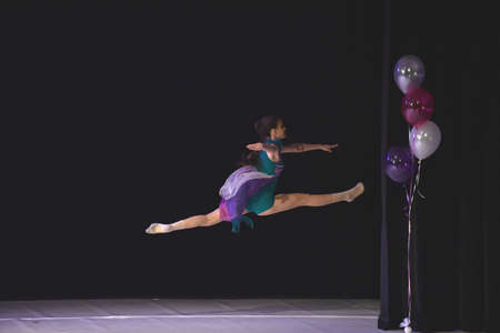 Young teenage girl performing modern dance on stage