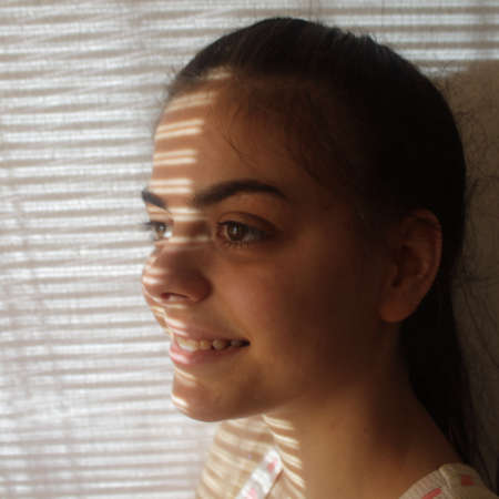 Close-up of a young girl's face looking out the window
